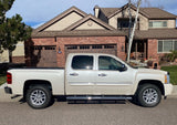 White Chevrolet Silverado with 18" silver OEM takeoff wheels and michelin tires